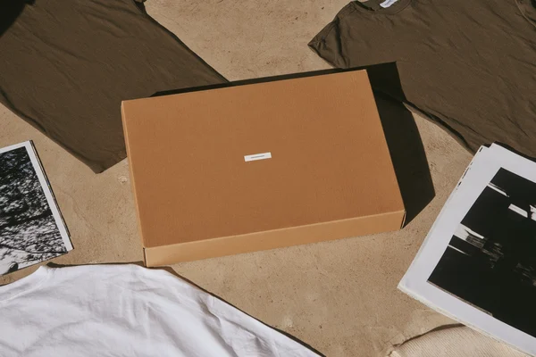 Cardboard box surrounded by clothing and prints