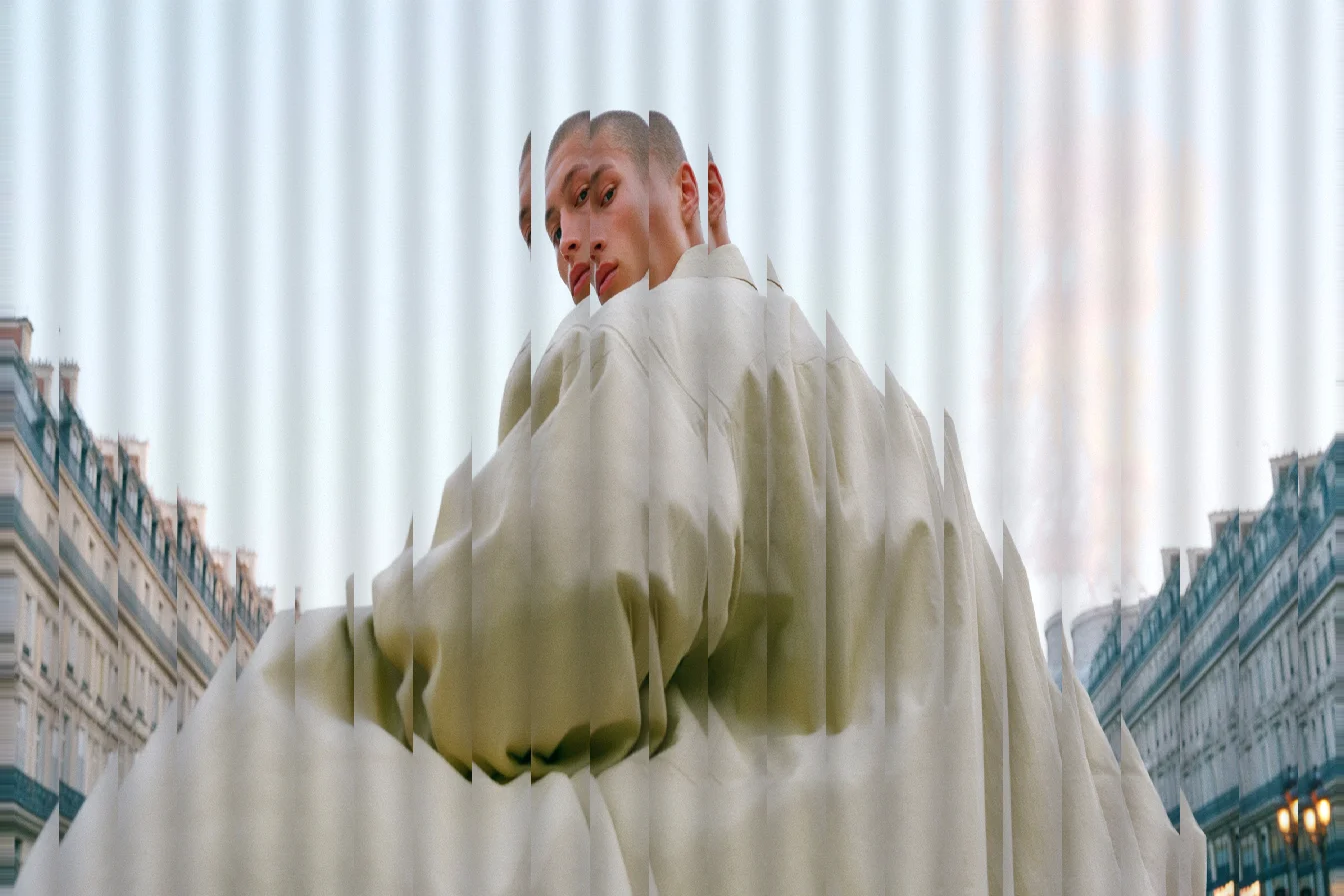 Person in a cream puffer coat on a city street, refracted into vertical strips as if seen through ribbed glass