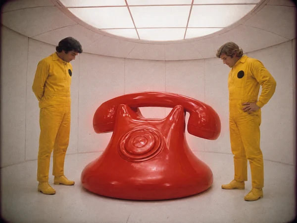 Two Men Observing a Giant Red Telephone