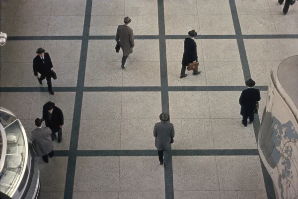 Businessmen Walking in a Grid Patterned Hallway