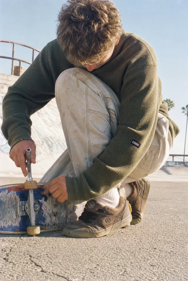 Skateboarder Adjusting Equipment at Skatepark