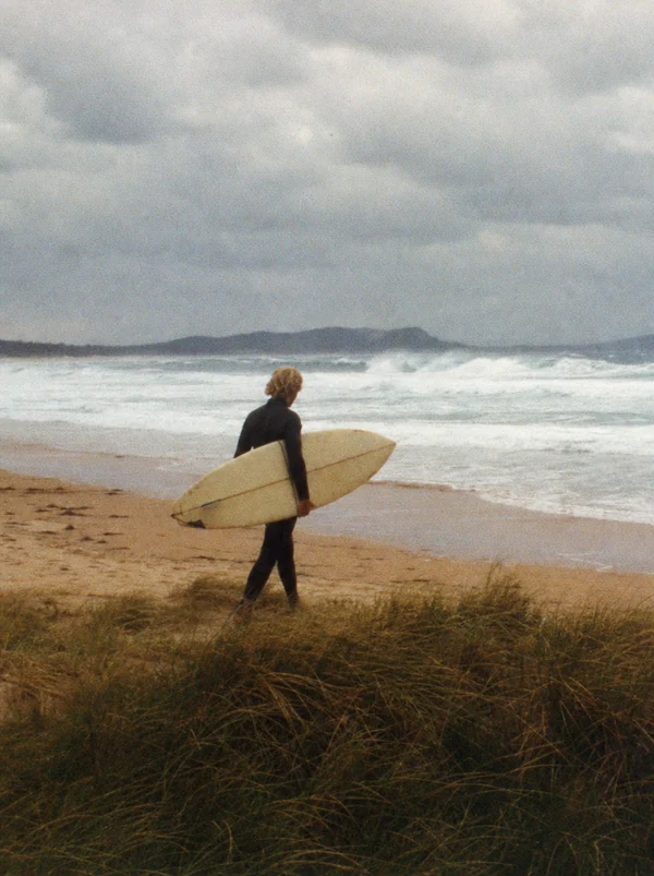 Surfer Walking Along the Beach
