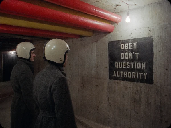 Two Men Observing a Sign in a Concrete Tunnel