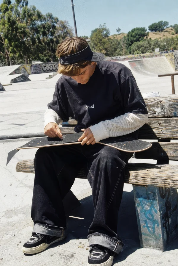 Skateboarder Preparing Board at Skatepark