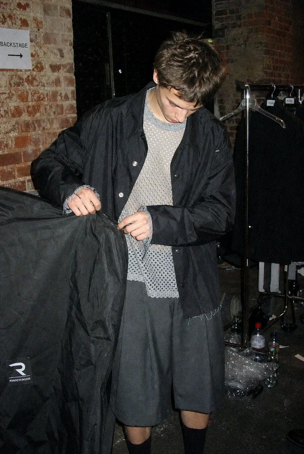 Young man preparing clothes backstage