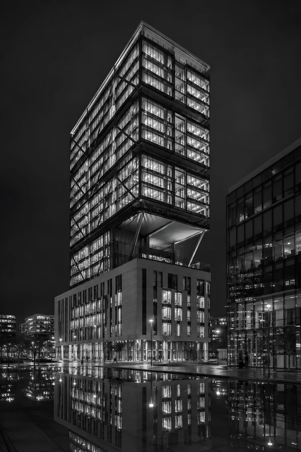 Modern Skyscraper at Night with Water Reflection