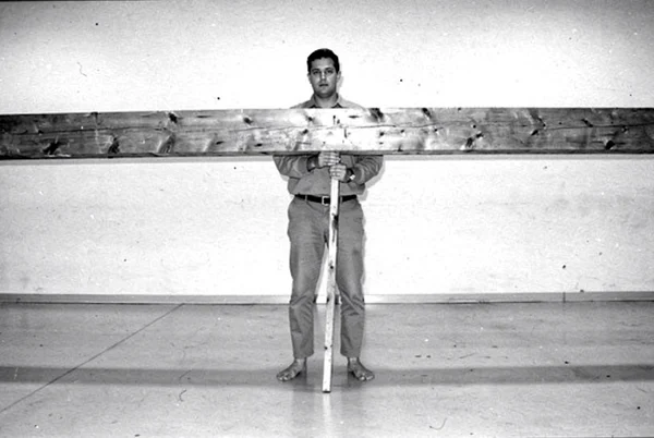 Man Holding a Large Wooden Beam