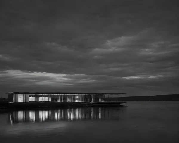 Modern Glass Pavilion by the Lake at Night