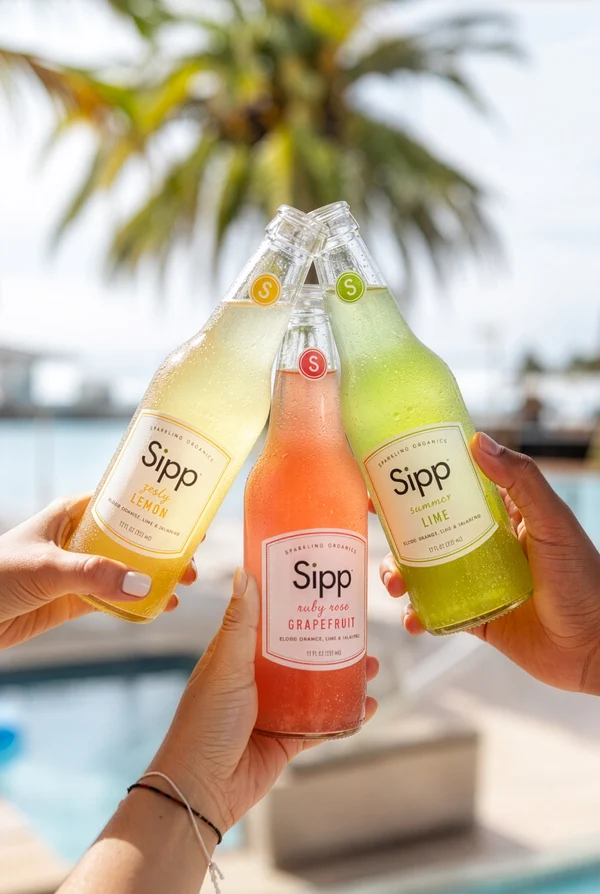 Three Hands Clinking Colorful Soda Bottles