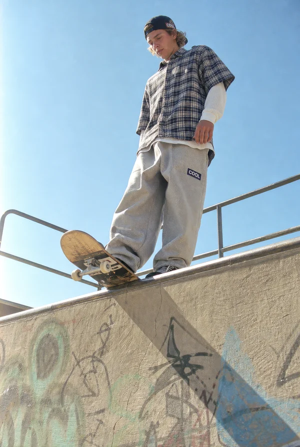 Skateboarder Standing on a Concrete Ledge