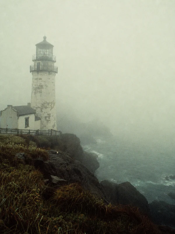 Lighthouse on a Foggy Coastal Cliff