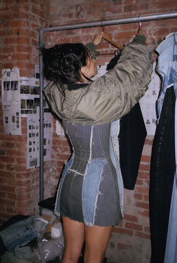 Woman Organizing Clothes in a Studio