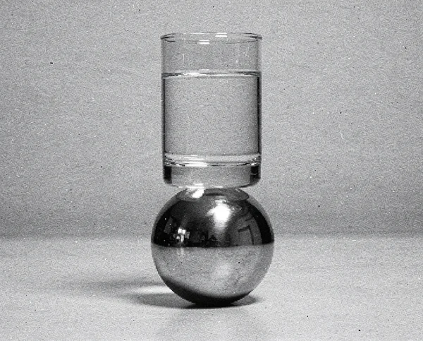 A Glass of Water Balanced on a Metallic Sphere