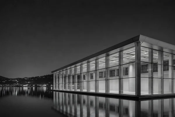 Modern Glass Building Reflected on Water at Night