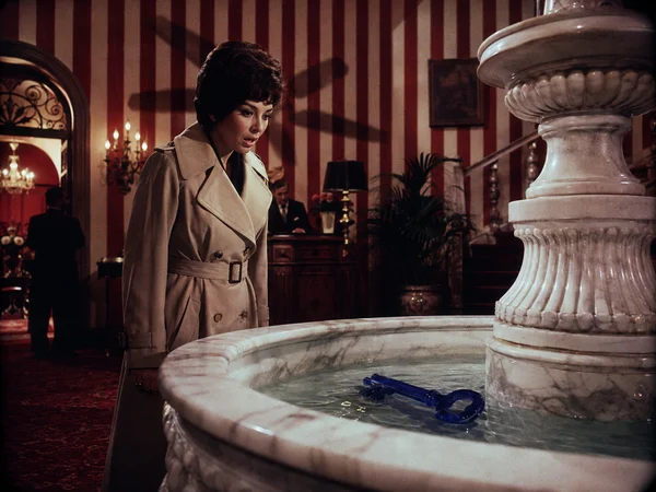 Woman Looking at a Blue Key in a Fountain