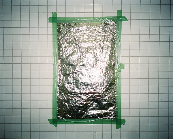 Silver Foil Sheet Taped to a Tiled Wall