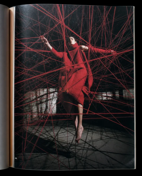 Model Suspended in a Red Yarn Web