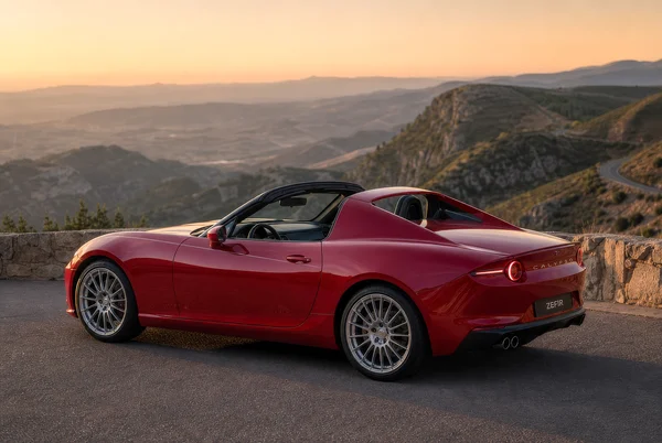 Red Sports Car on a Mountain Road at Sunset