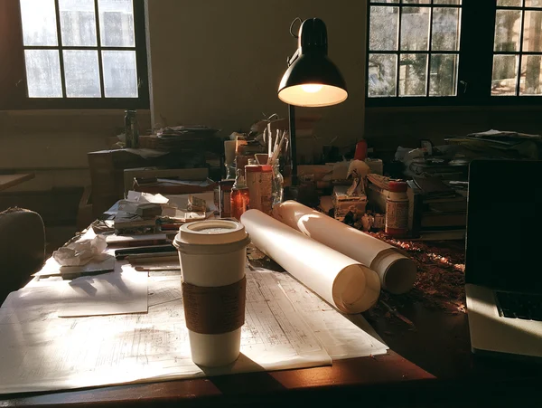 A Cluttered Creative Workspace at Sunset