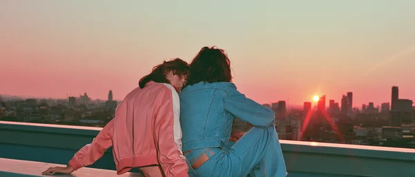Friends Watching the Sunset Over the City Skyline