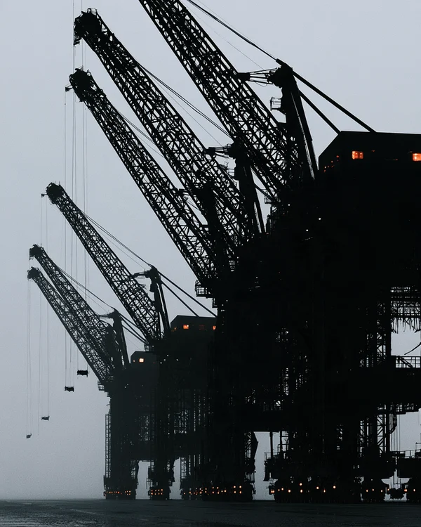 Silhouetted Industrial Cranes at the Harbor